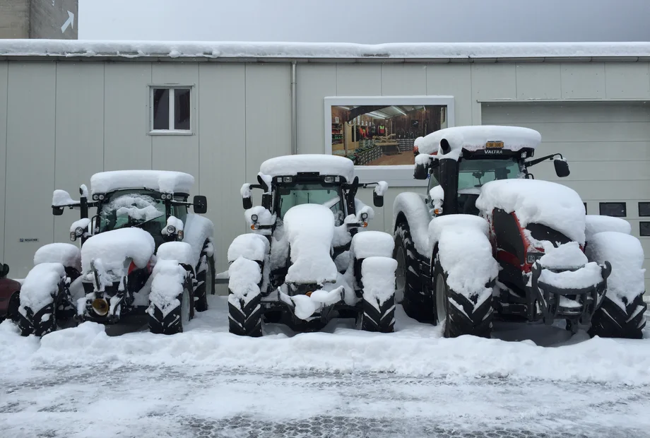 Valtra-Traktoren im Schnee vor der Werkstatt
